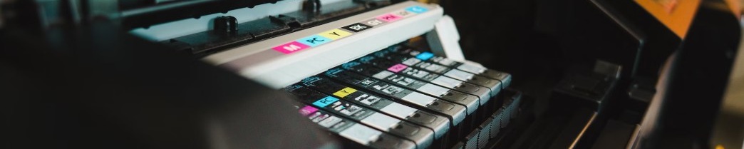 Närbild av öppen bläckstråleskrivare med färgpatroner i magenta, cyan, gul och svart